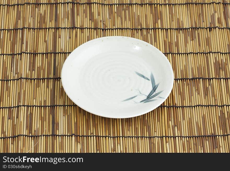 A bamboo paint asian dish on bamboo mattress. A bamboo paint asian dish on bamboo mattress