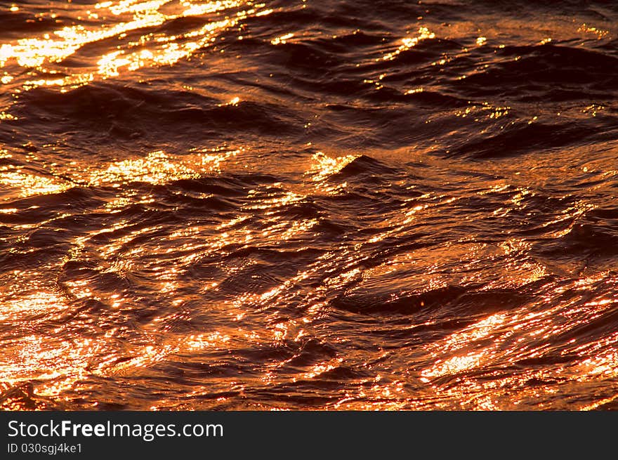 Sea waves sparkling at sunset