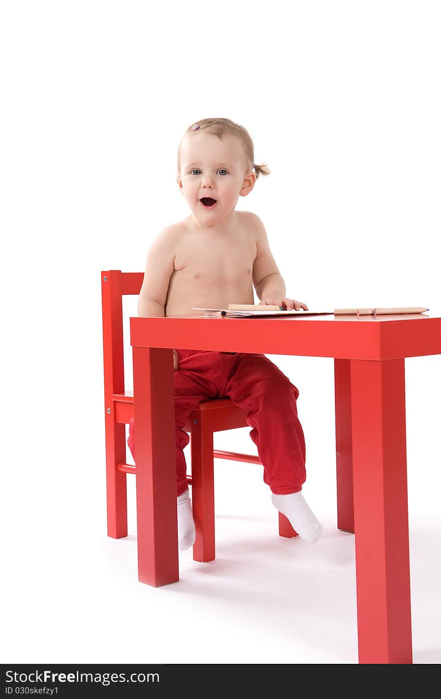 Baby girl is making fun sitting on the table. Baby girl is making fun sitting on the table