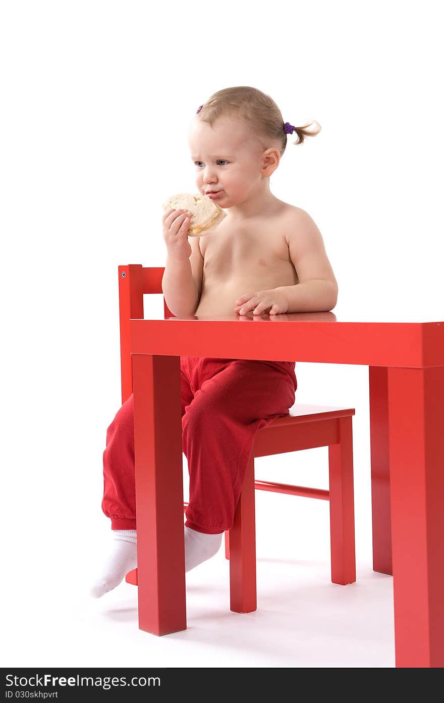 Little baby girl is sitting on the red chair