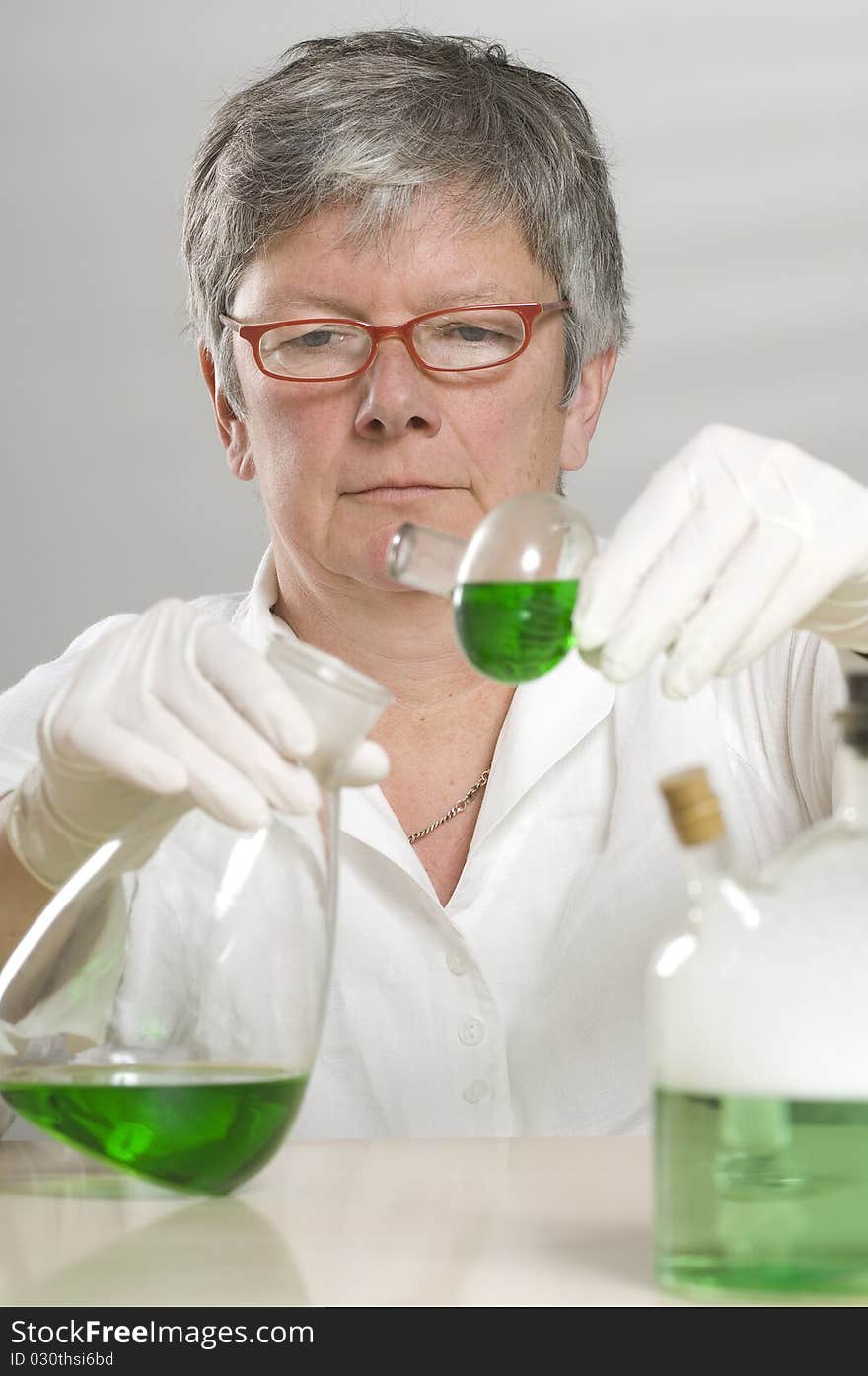 Scientist is working with a green liquid