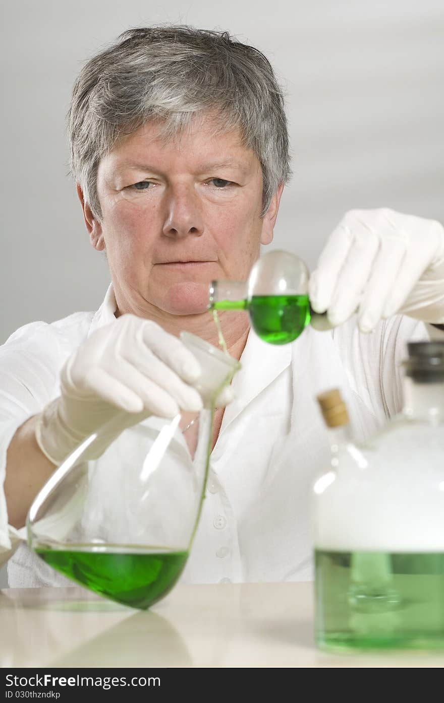 Scientist is working with a green liquid