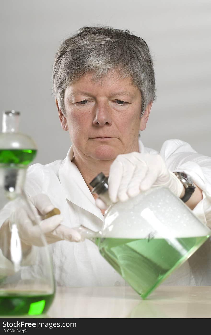 Scientist is working with a green liquid