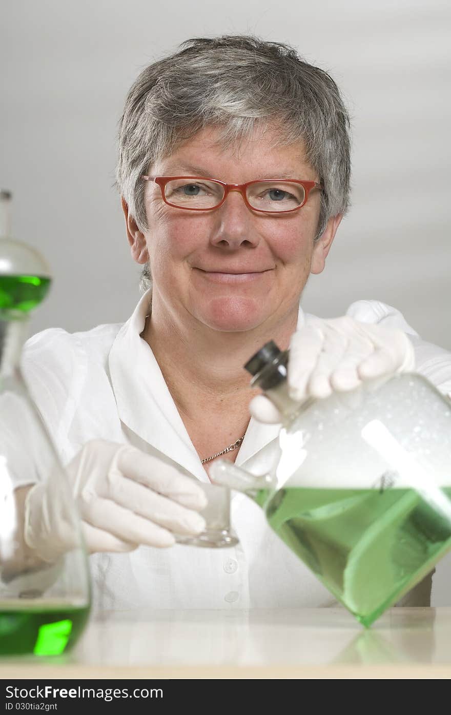 Scientist is working with a green liquid