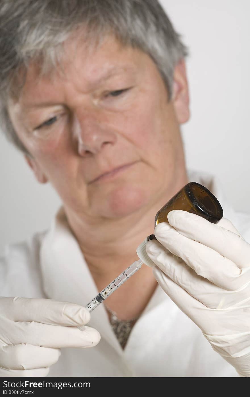 Female Doctor Holding Needle And Bottle