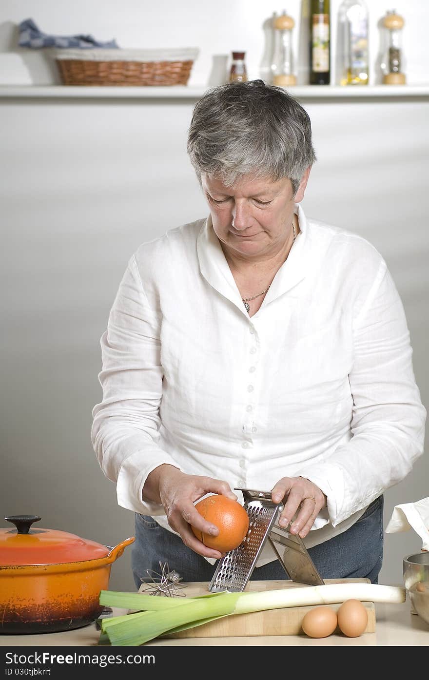 Women is using a grater in the kitchen