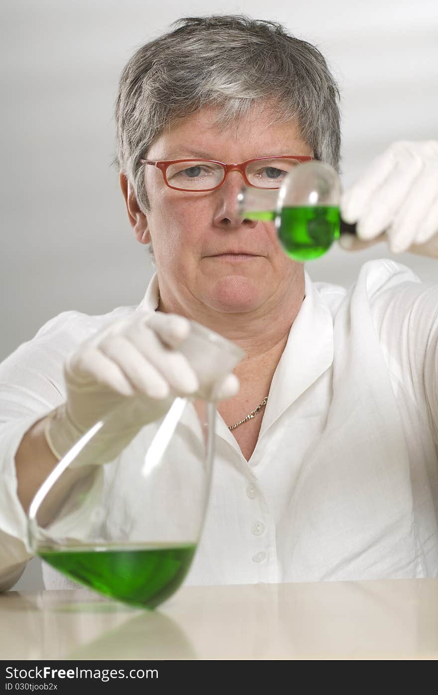 Scientist is working with a green liquid