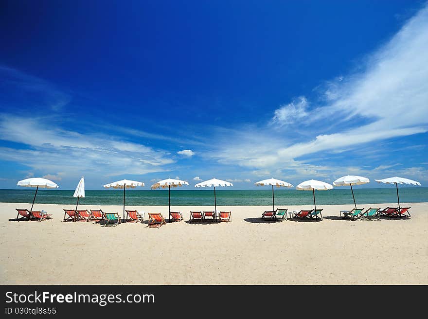 Beach chairs with umbrellas on a sunny day