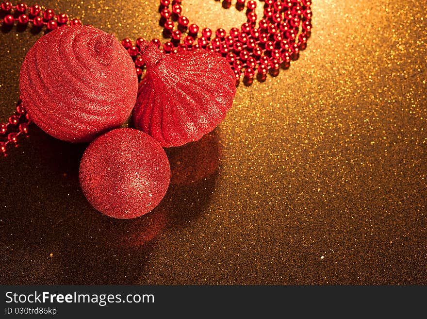 Red glitter Christmas baubles on golden glitter background - copy space. Red glitter Christmas baubles on golden glitter background - copy space