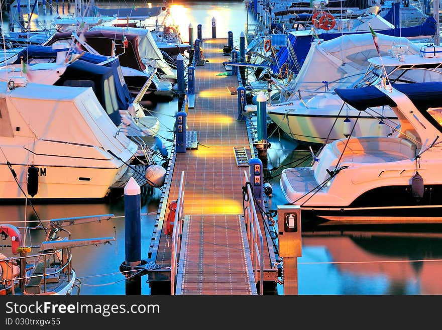 View of a pier in a marina at sunset hour