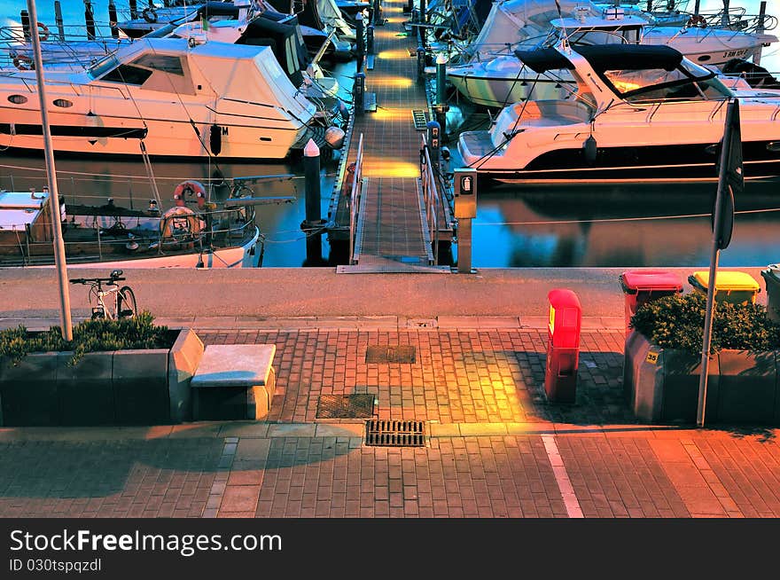 View of a pier in a marina at sunset hour