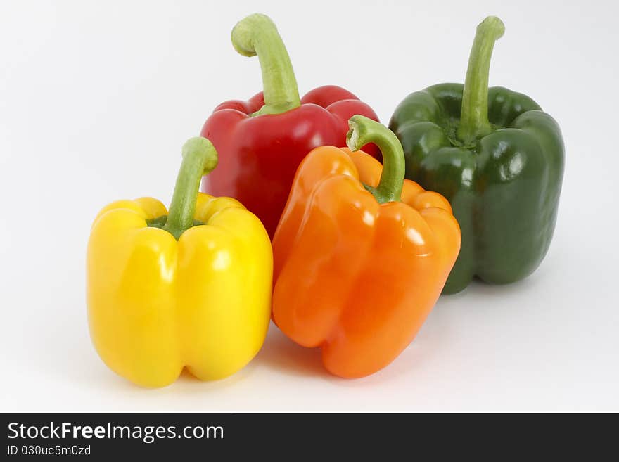 Studio shot, colored peppers in front of a white background