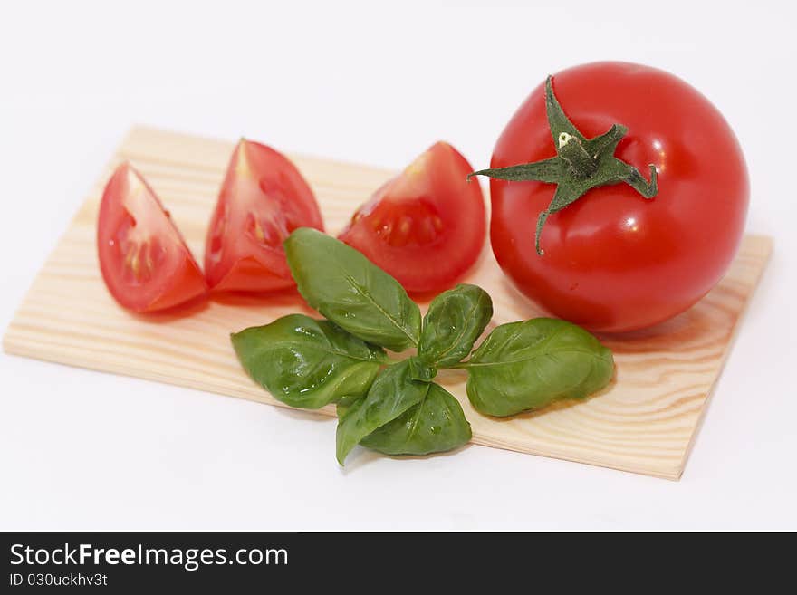 Studio shot, sliced tomato with basil in front of a white background