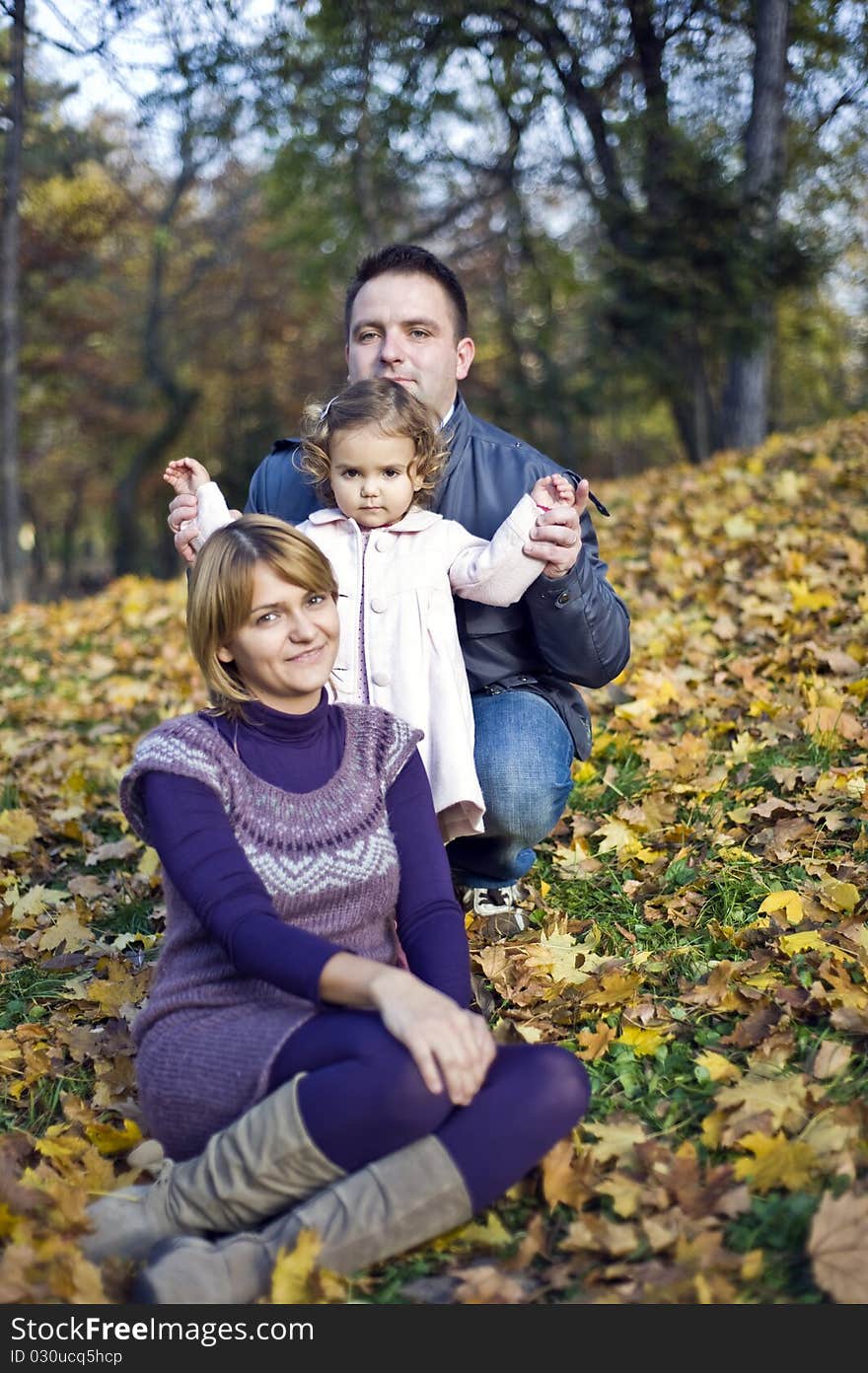 Happy family, mom, dad and little girl in the park in autumn. Happy family, mom, dad and little girl in the park in autumn