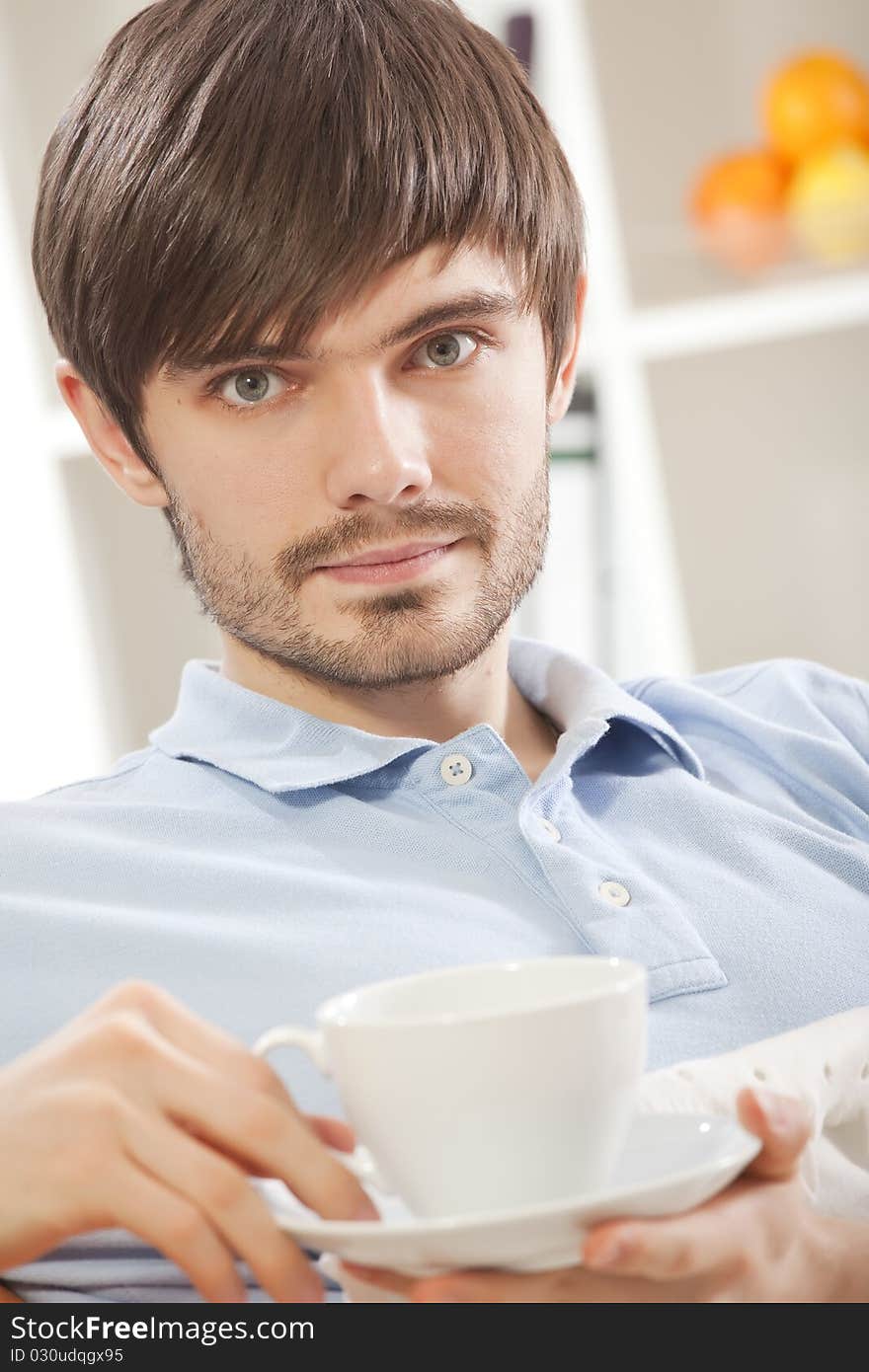 Man with cup tea on sofa