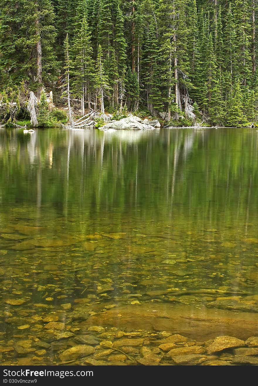 Emerald Lake in the Rocky Mountain National Park, Colorado. Crystal clear green water and lined with pine trees. Emerald Lake in the Rocky Mountain National Park, Colorado. Crystal clear green water and lined with pine trees.