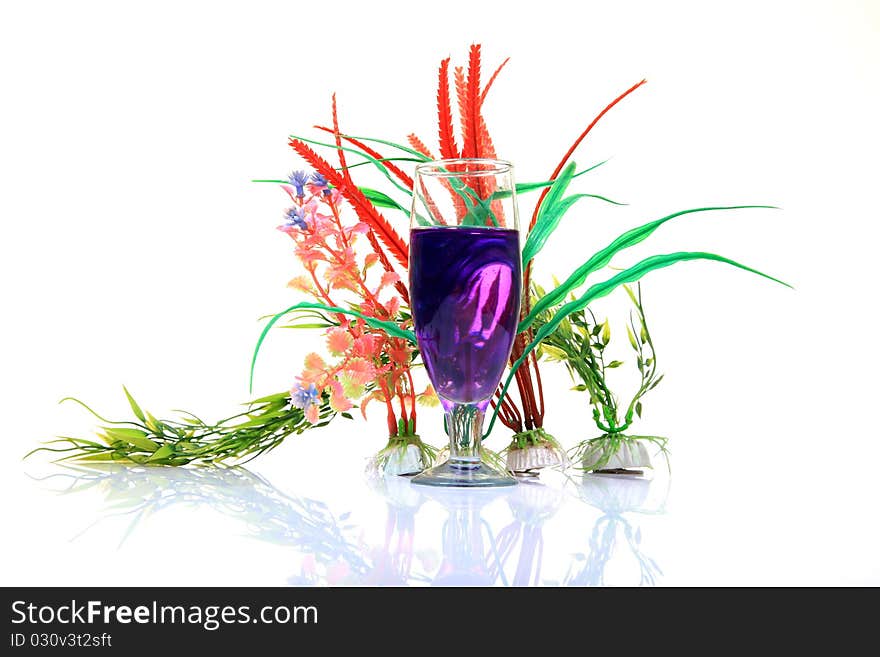 Blue mocktail glass with natural plants on white background.