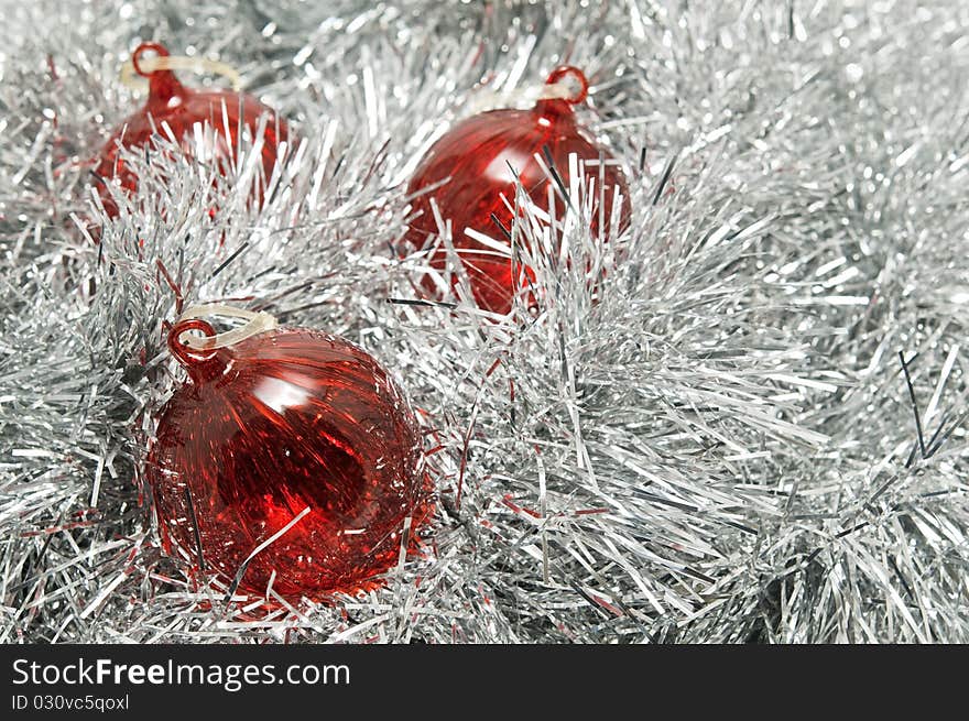 Three red glass baubles on a bed of silver tinsel. Three red glass baubles on a bed of silver tinsel.