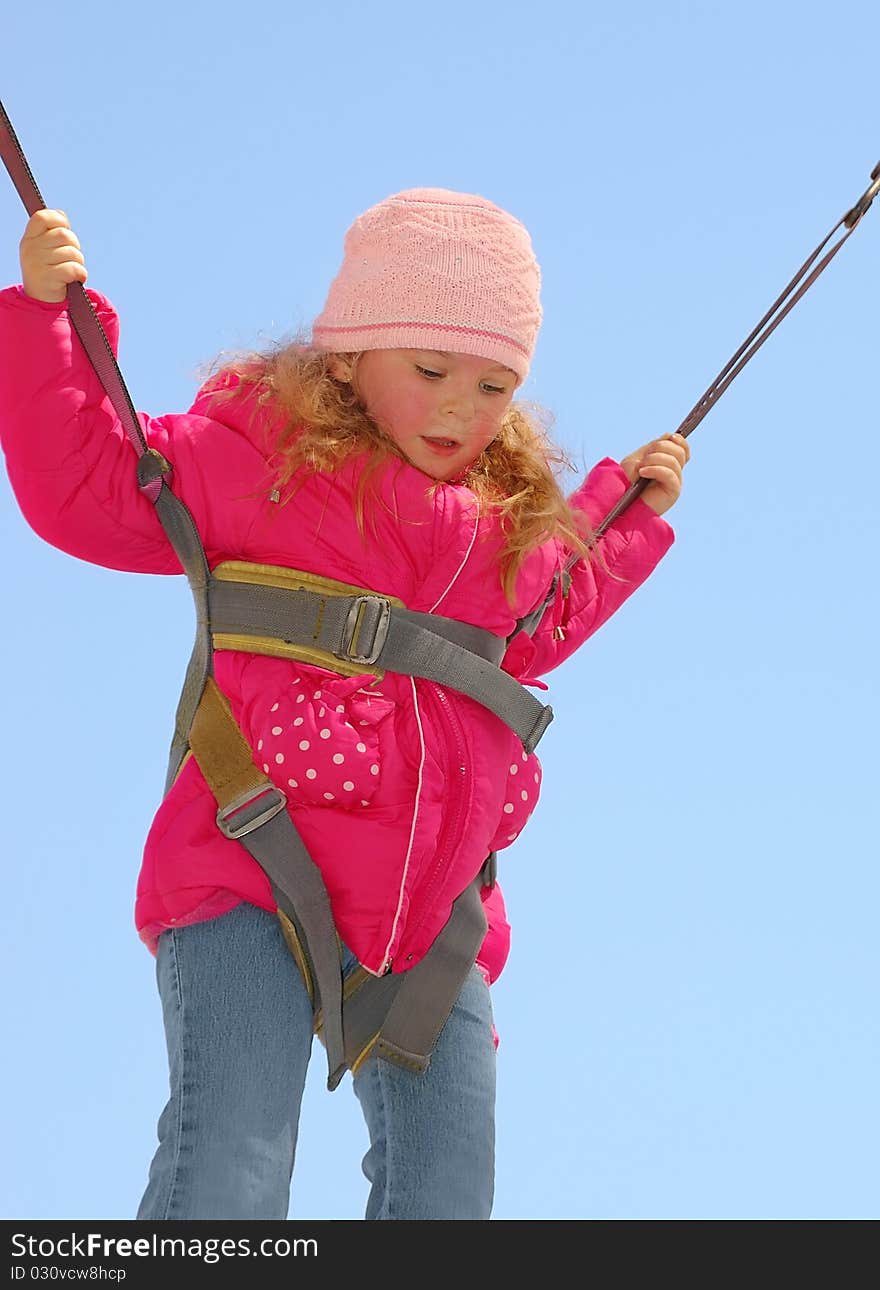 The girl in a jump against the blue sky