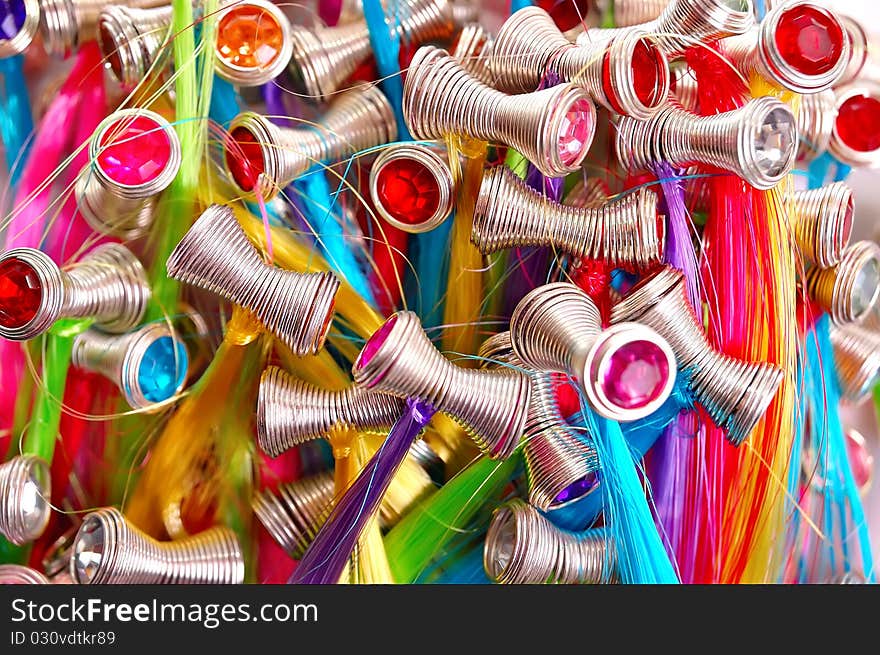 Multicolored background from hairpins in the form of a spring with artificial hair