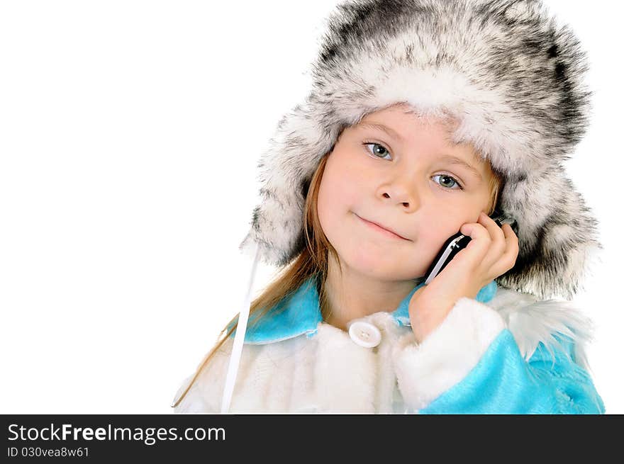 The girl in a winter fur cap speaks by phone on a white background