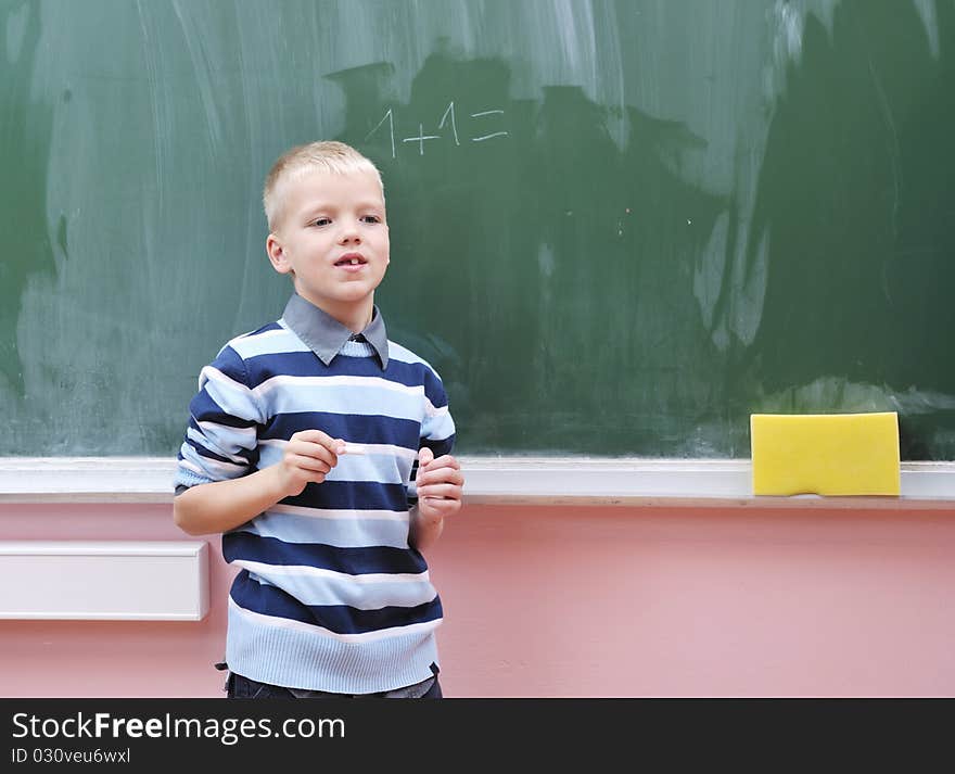 Happy young boy at first grade math classes solving problems and finding solutions