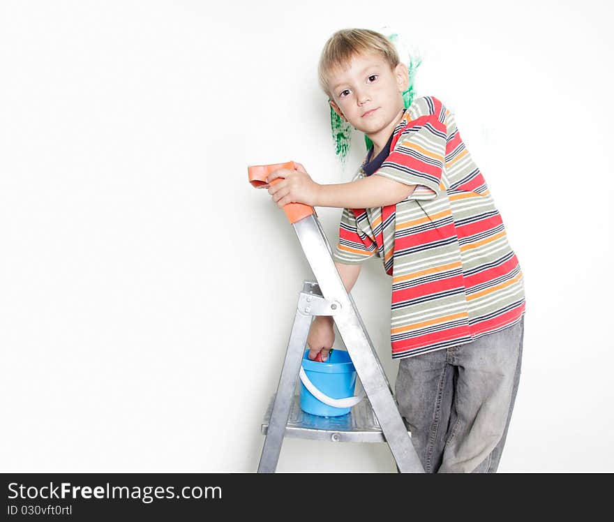 Young boy painting over white