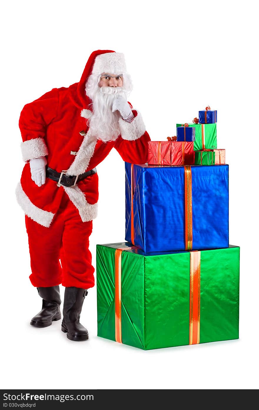 Serious and thoughtful Santa Claus standing, leaning on a box with gifts. Isolated on white. Serious and thoughtful Santa Claus standing, leaning on a box with gifts. Isolated on white.