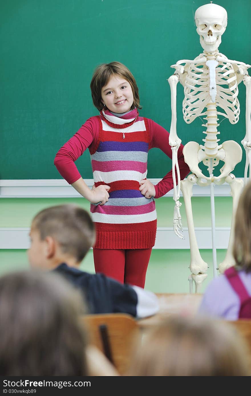 Happy children group in school classrom taking notes and learning biology and anatomy lessons with teacher. Happy children group in school classrom taking notes and learning biology and anatomy lessons with teacher