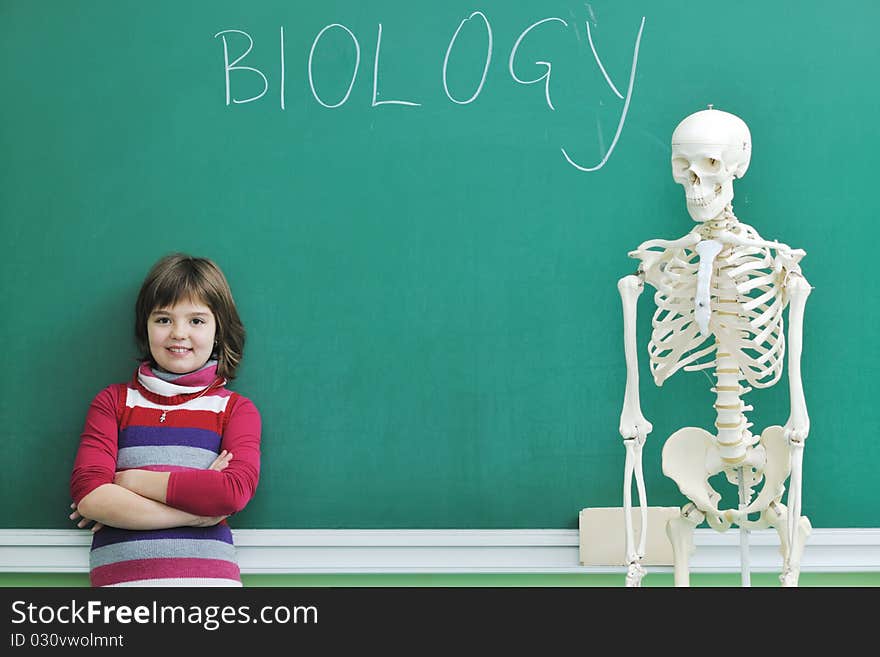 Happy children group in school classrom taking notes and learning biology and anatomy lessons with teacher. Happy children group in school classrom taking notes and learning biology and anatomy lessons with teacher