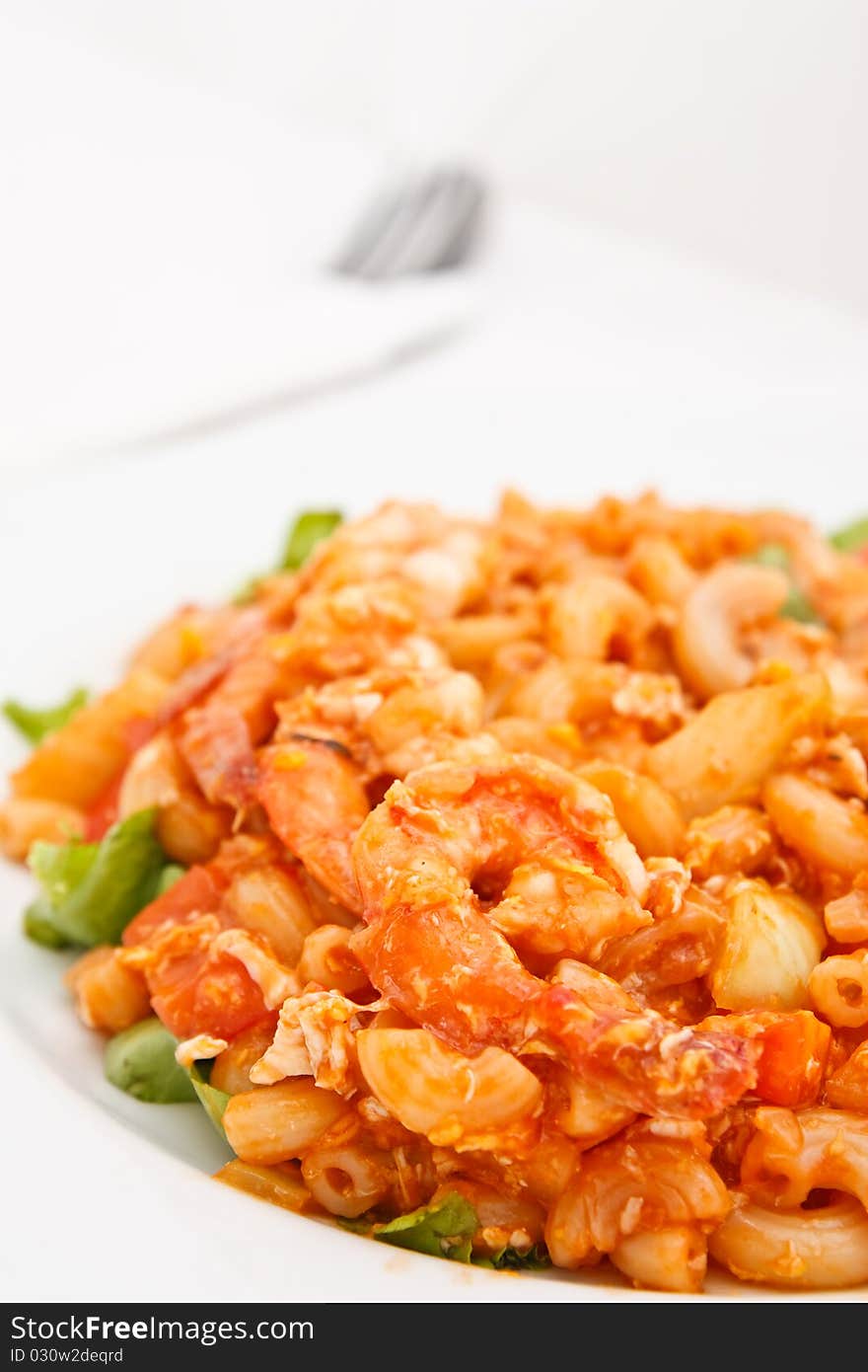 Colorful fried macaroni and fork in background. Colorful fried macaroni and fork in background