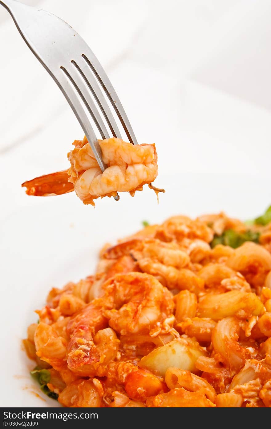 Colorful fried macaroni and fork in background. Colorful fried macaroni and fork in background