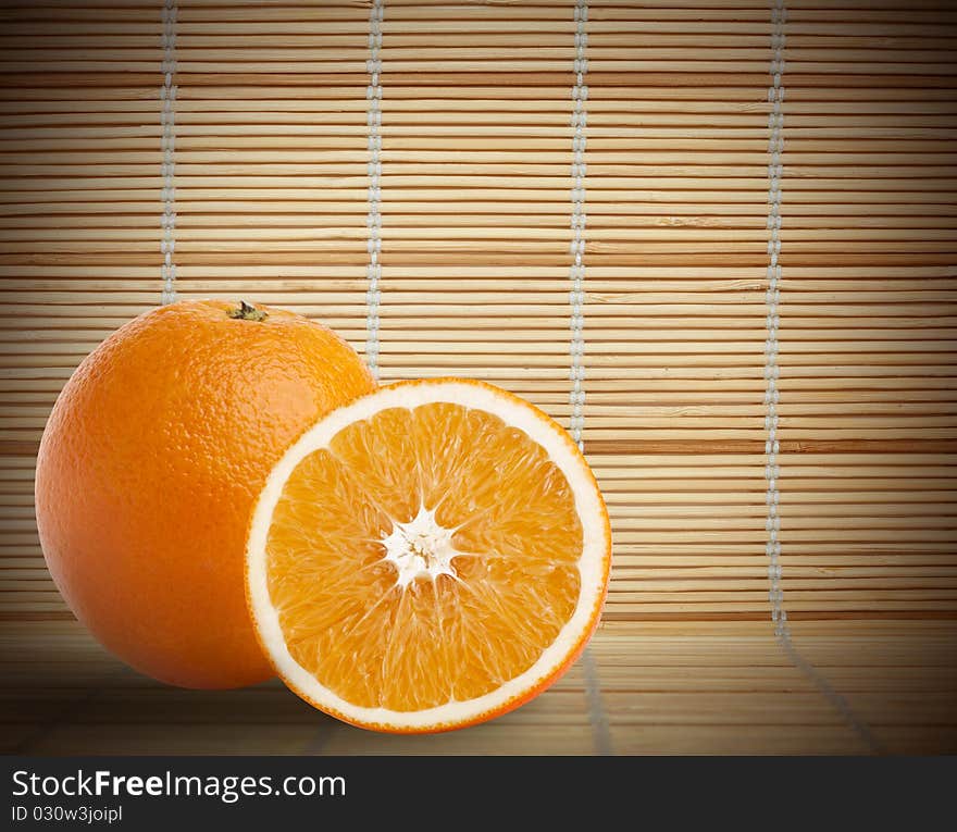 One and half oranges on bamboo mat