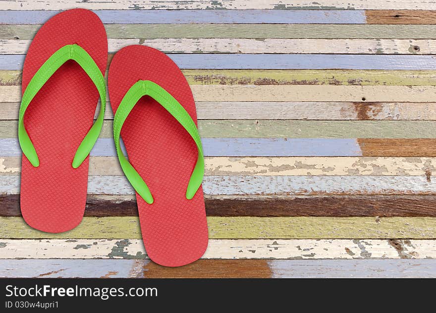 Red and green flip flop sandals on old wood