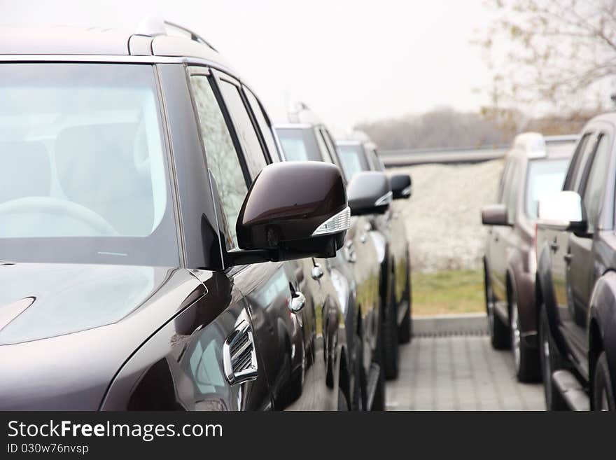 Group of cars stand in one number of dark color