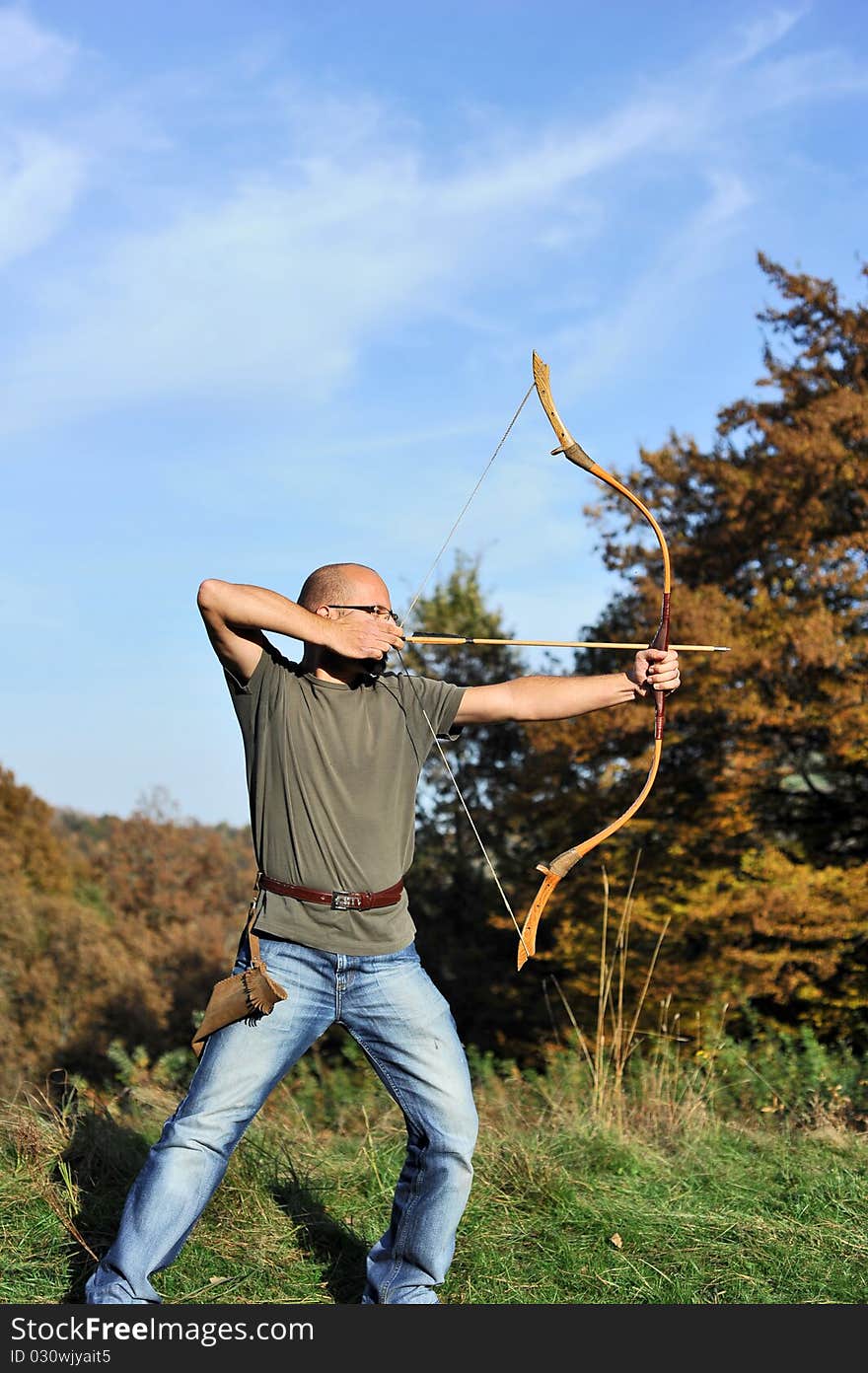 Man holding back an arrow and aiming to shoot. Man holding back an arrow and aiming to shoot.