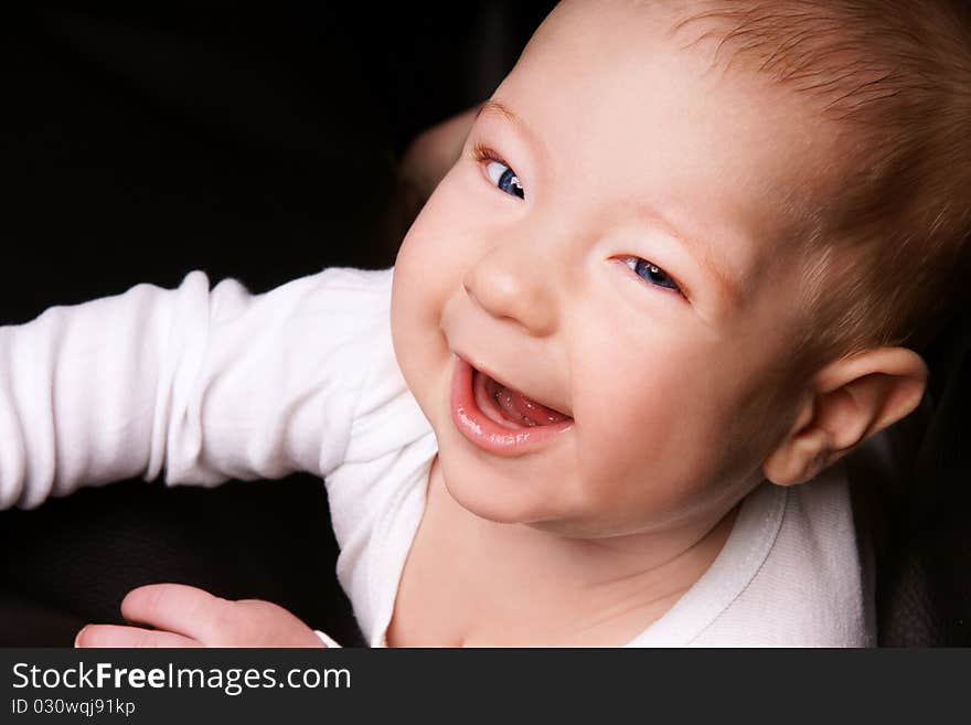 Portrait of joyful blue-eyed baby boy, studio shot