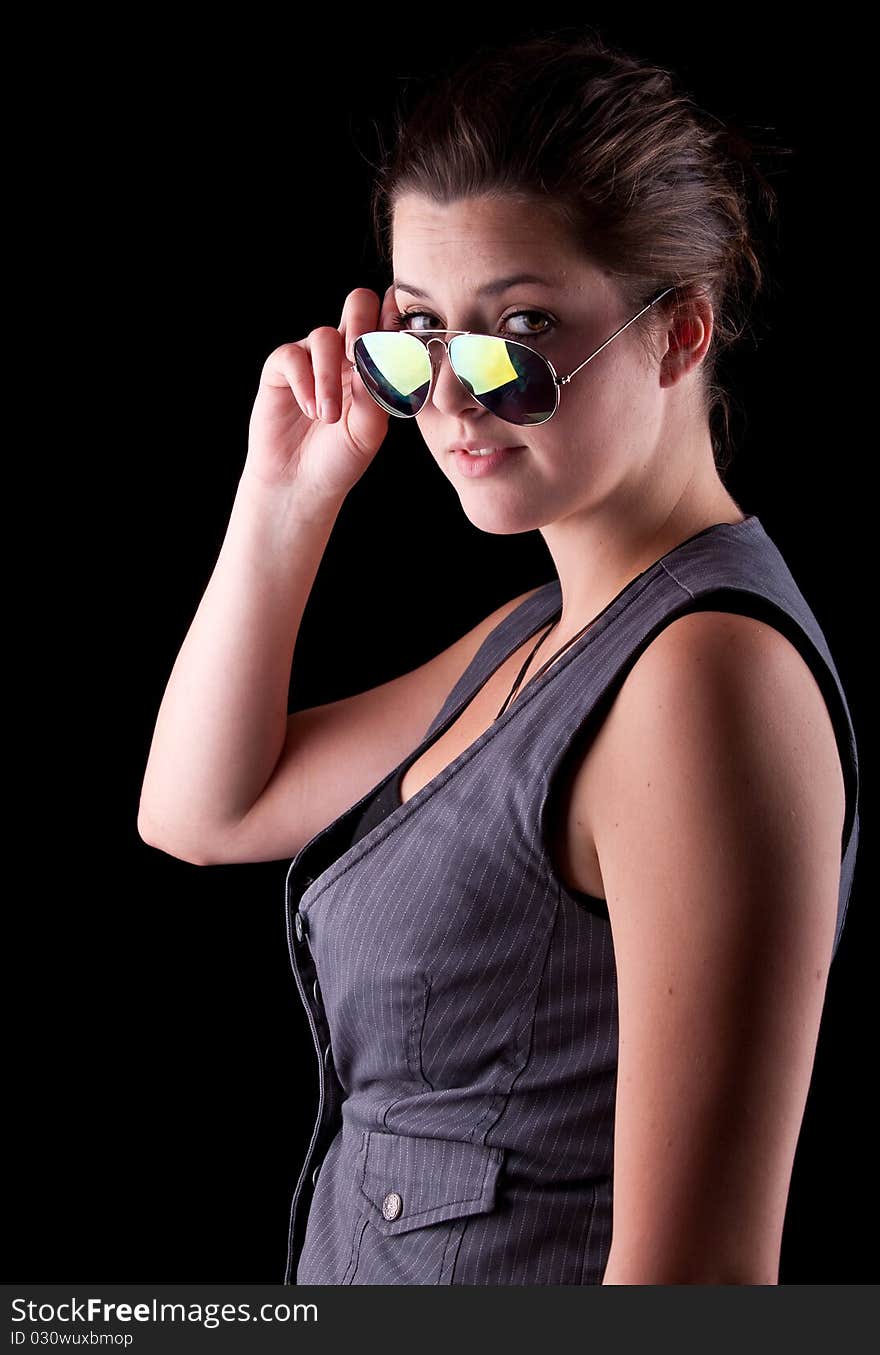 Young woman with cool sunglasses isolated over a pure black background. Young woman with cool sunglasses isolated over a pure black background.