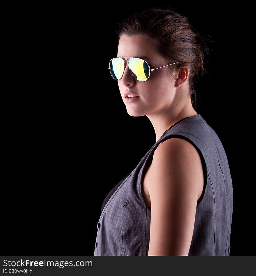 Young woman with cool sunglasses isolated over a pure black background. Young woman with cool sunglasses isolated over a pure black background.