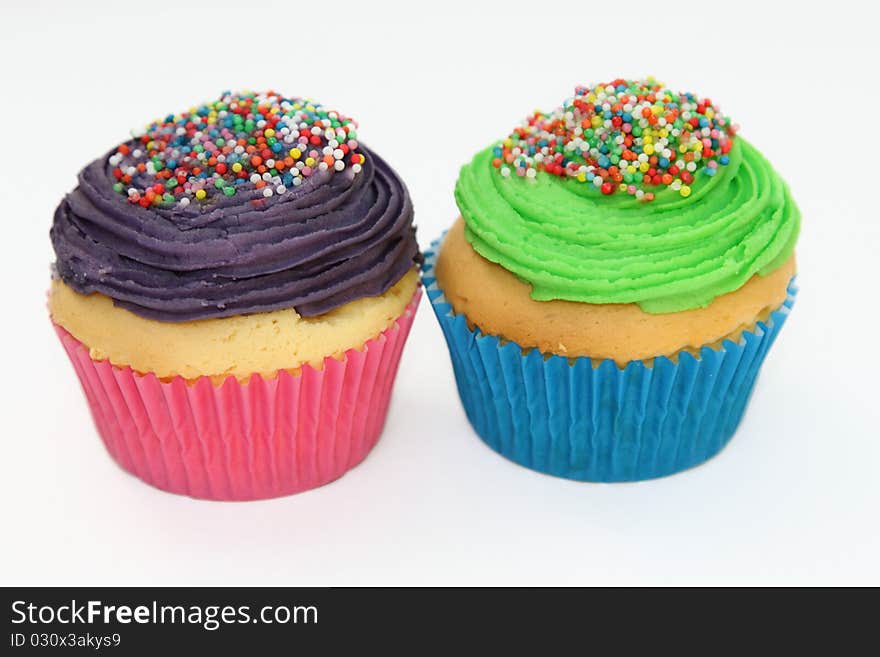 Colorful iced cupcakes with sprinkles.