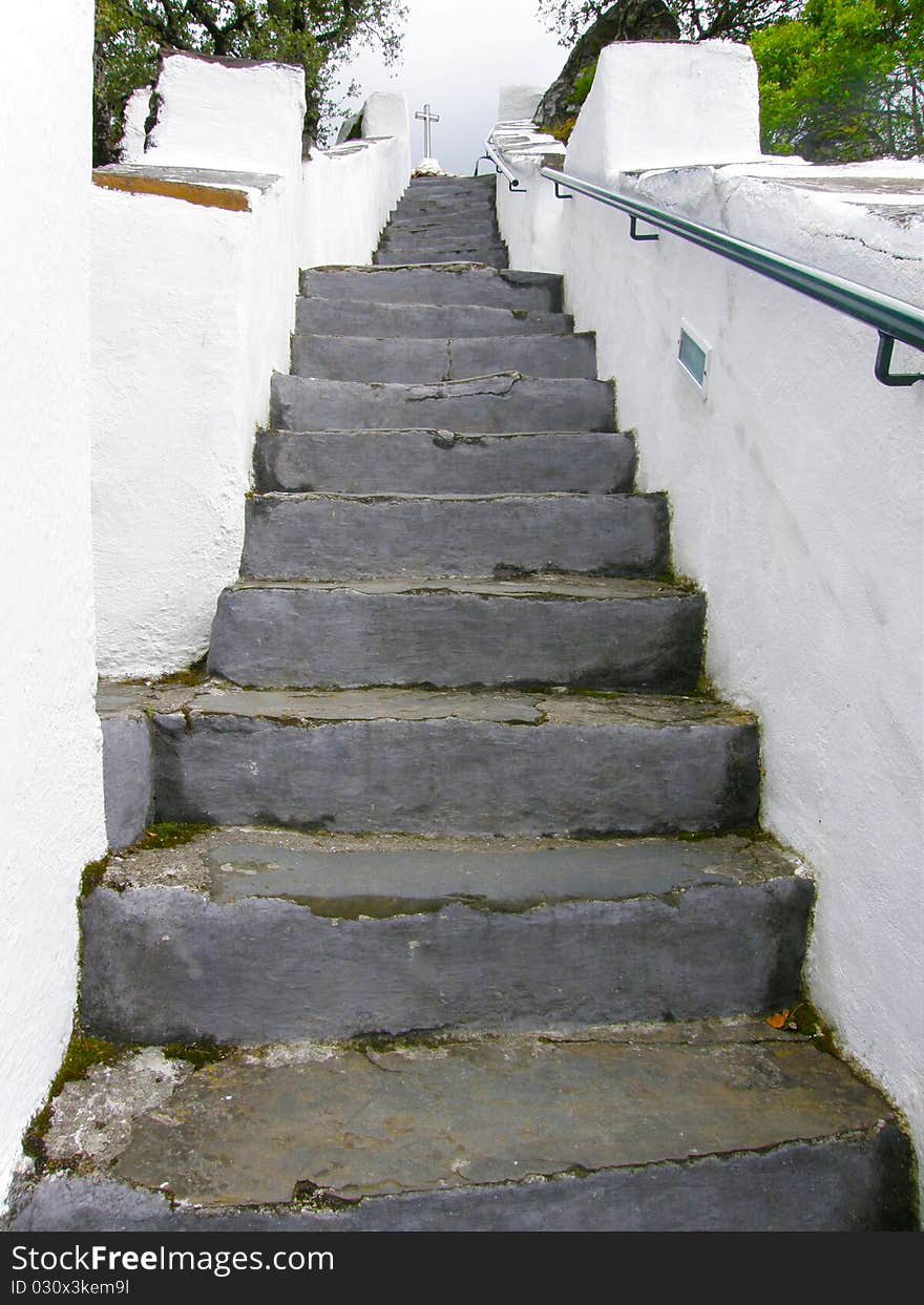 A white and gray stairway with a Cross at the top. A white and gray stairway with a Cross at the top.