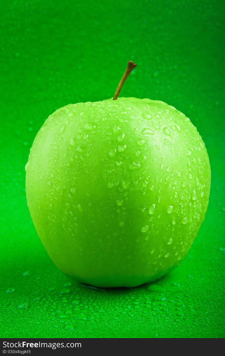 Fresh green apple with drops of water