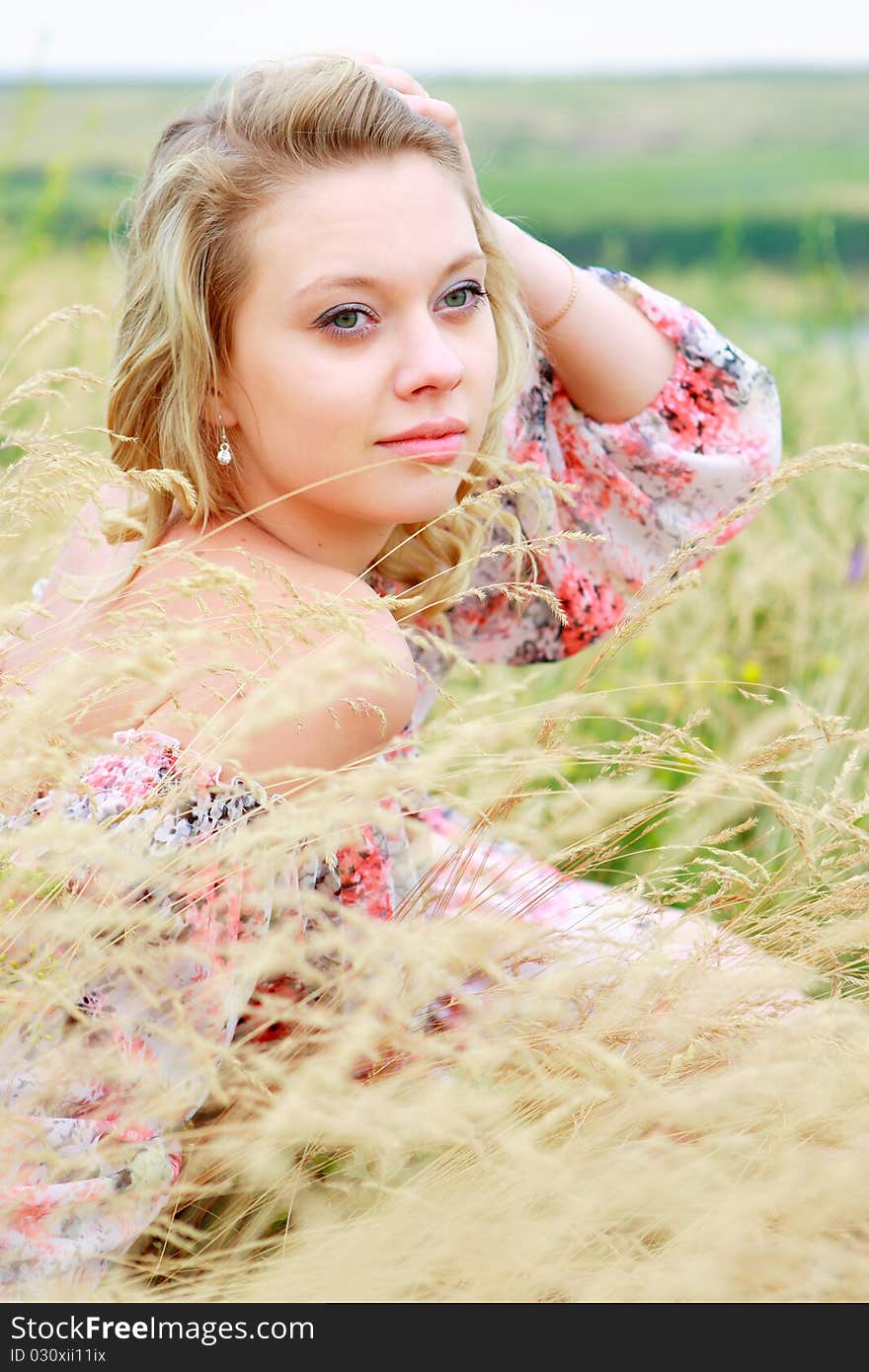 Portrait of the young girl on the nature among grasses and smiling on the chamber. Portrait of the young girl on the nature among grasses and smiling on the chamber