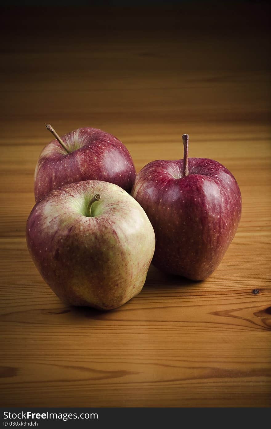 Three red apples on the wooden table. Three red apples on the wooden table