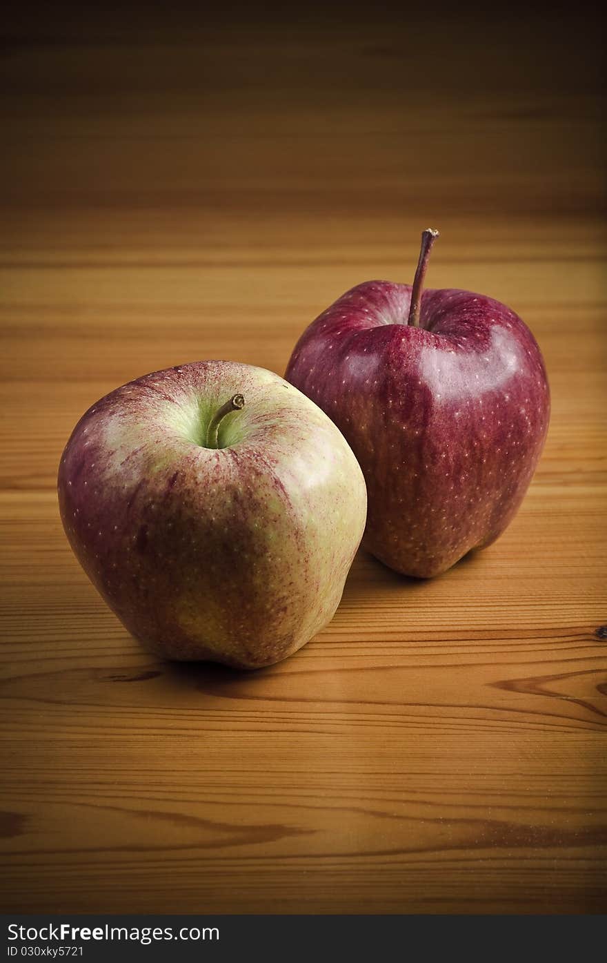 Two red apples on the wooden table. Two red apples on the wooden table