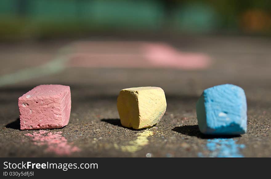 Colorful chalk on asphalt. Sunny day.