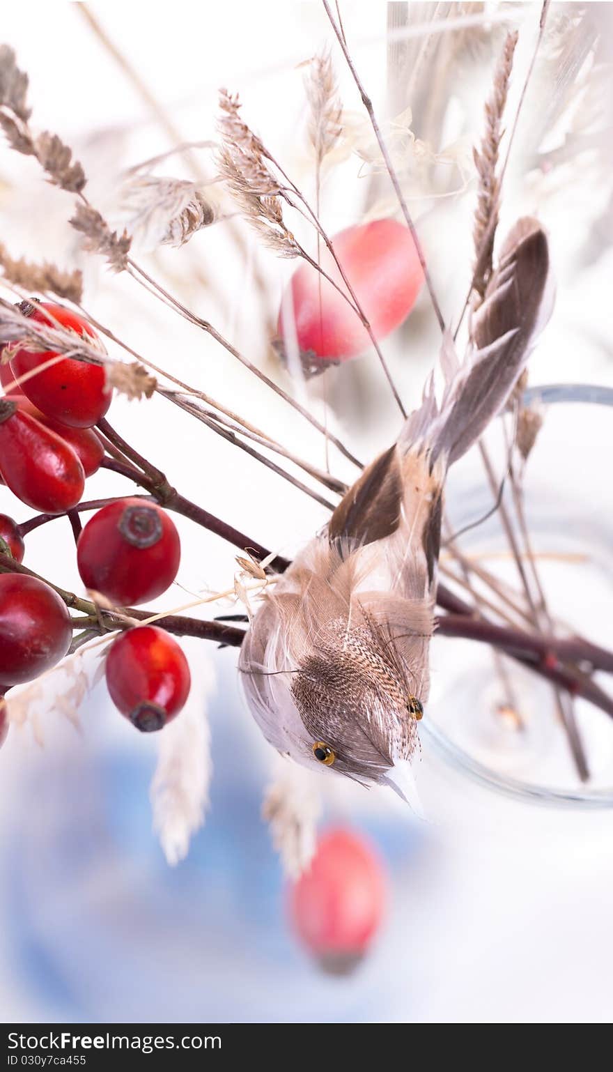 Autumn berries and artificial bird