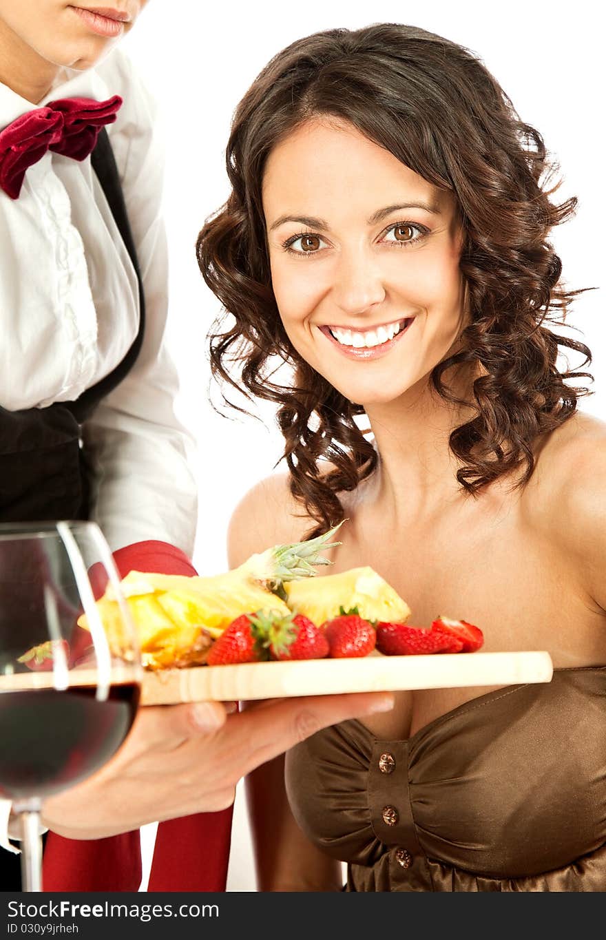 Beautiful smiling female being offered sliced fruits on by waitress. Beautiful smiling female being offered sliced fruits on by waitress