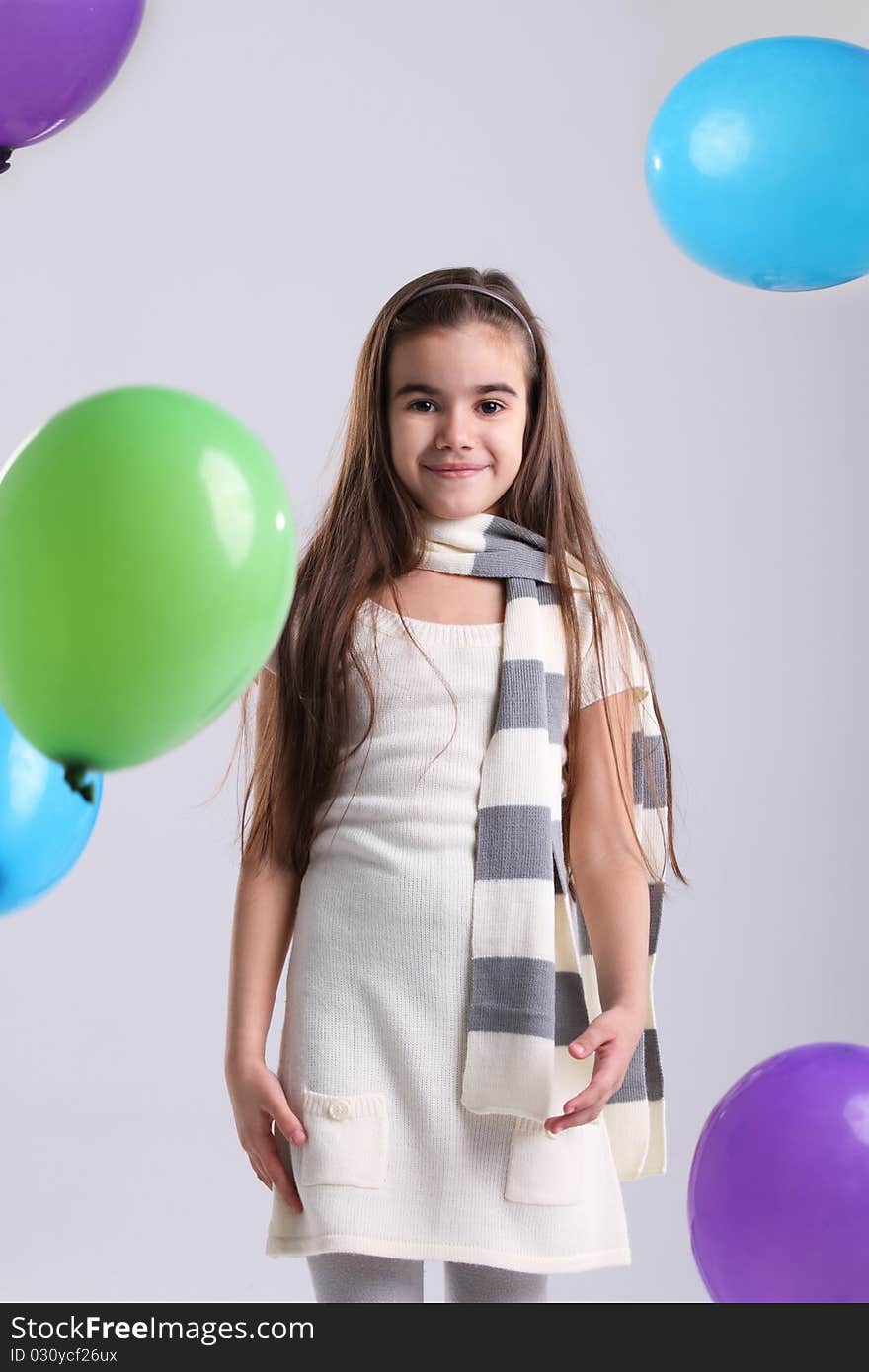 Little smiling girl with balloons in the studio