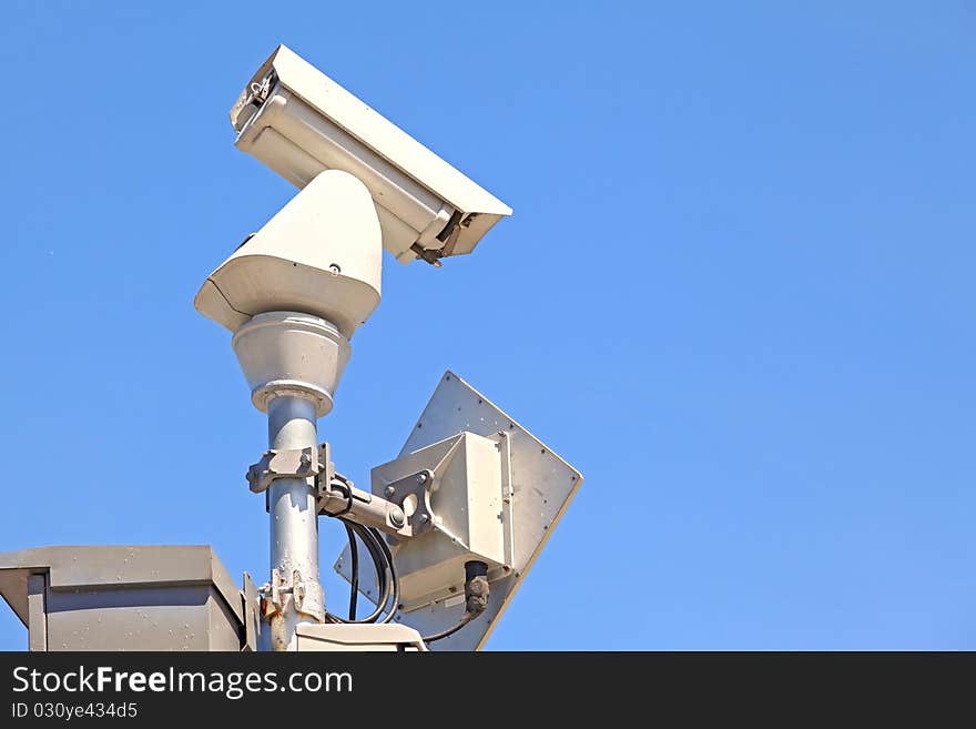 Closeup of isolated Surveillance Security Camera or CCTV on blue sky